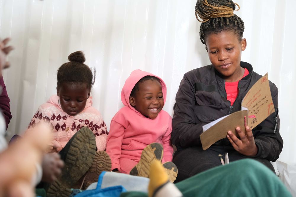 In the early childhood development project (edp), a care giver reads to two toddlers (source: Malte Pfau) In the early childhood development project (edp), a care giver reads to two toddlers (source: Malte Pfau)