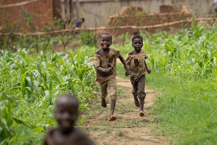 Two boys in ripped clothes run across a path (Source: Christian Nusch)