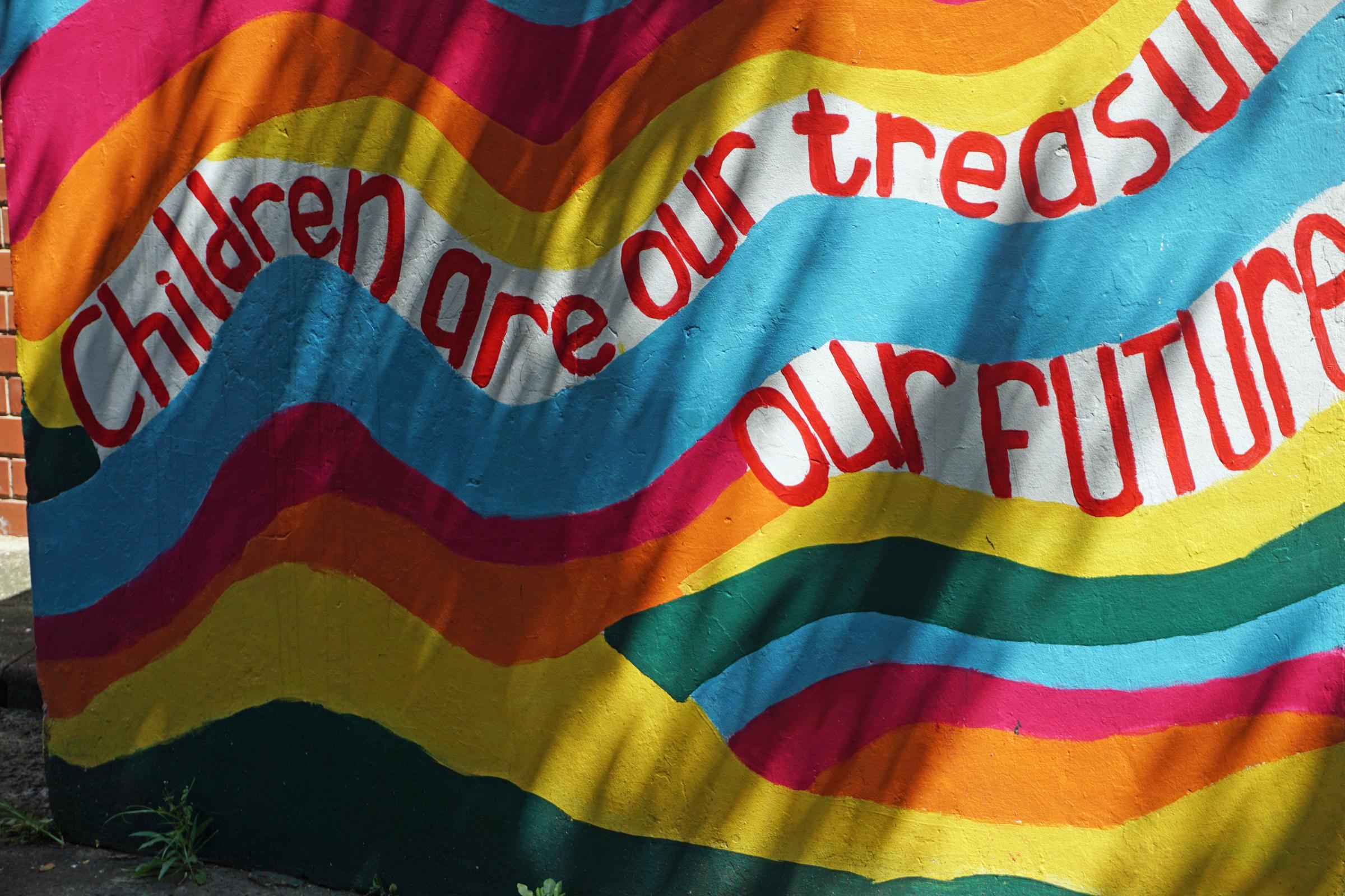 Colourful graffiti on a wall "Children are our treasure/our future" (source: Lorenz Toepperwien/KNH)