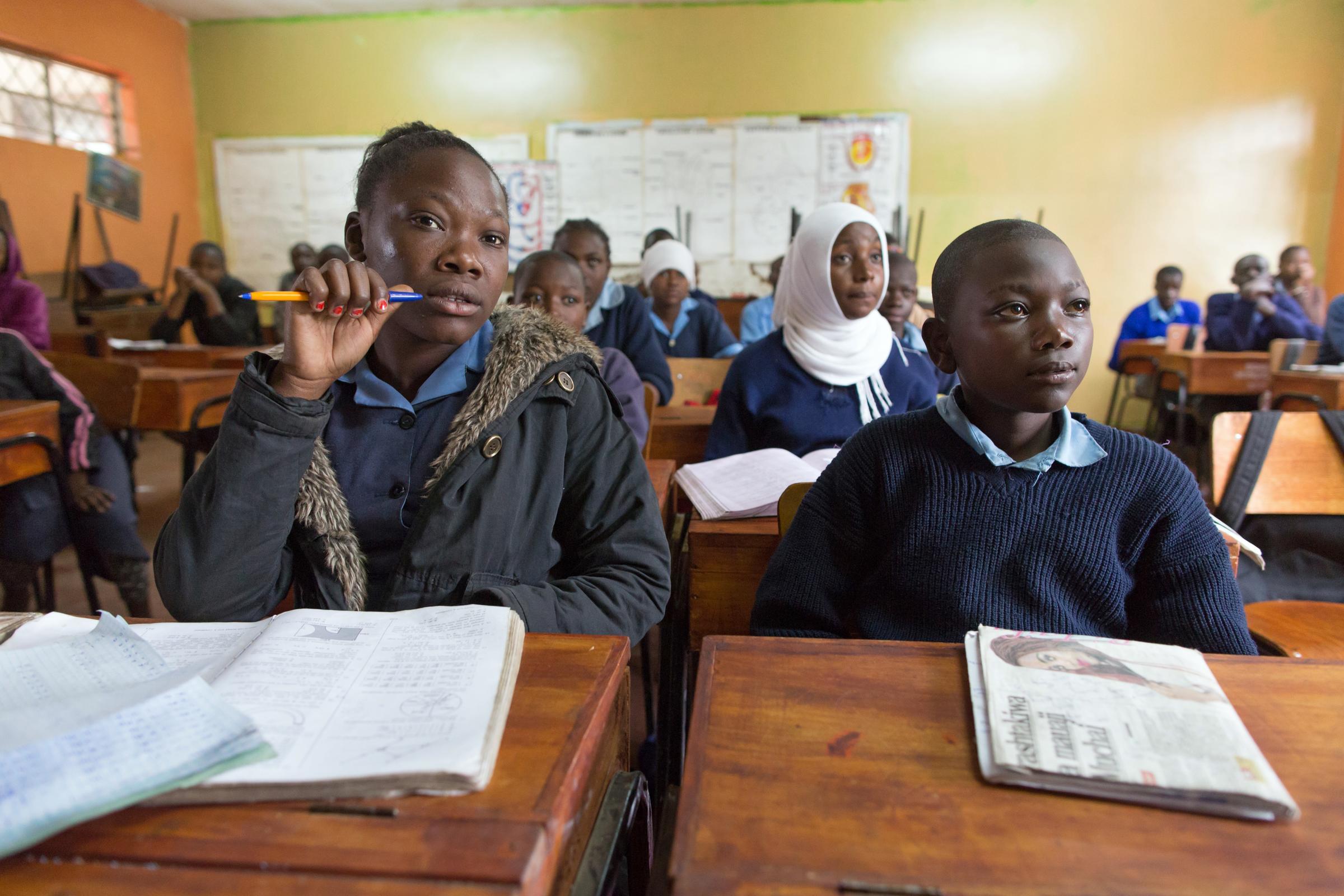 Pupils sit at desks in a class room (source: KNH/Gemeinsam für Afrika/Stefan Trappe)