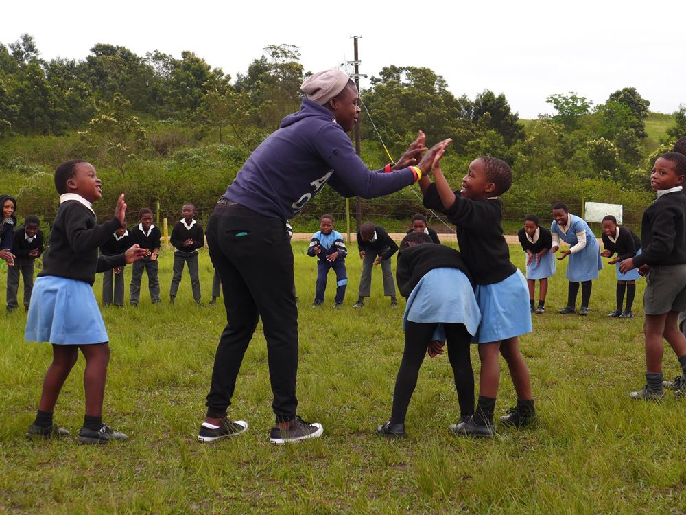 Children play in a circle outside a clapping game with a care giver (source: Niklas Alof) Children play in a circle outside a clapping game with a care giver (source: Niklas Alof)